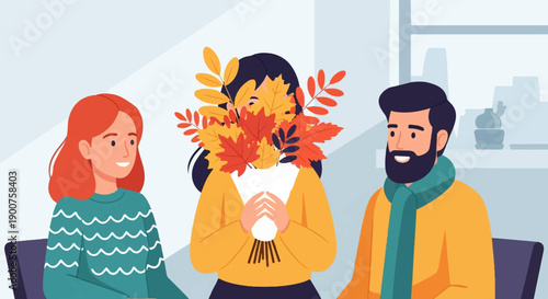 Three people sitting together, one holding autumn leaves