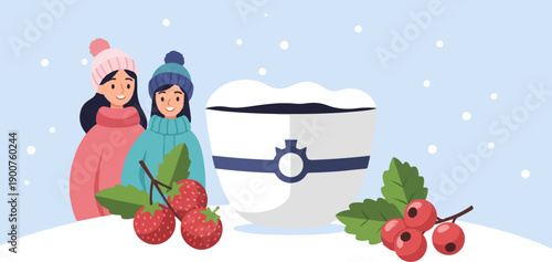 Two girls in winter hats and sweaters stand near a snowball-covered mug with berries