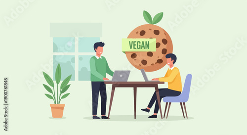 Two people working on laptops beside a giant vegan cookie