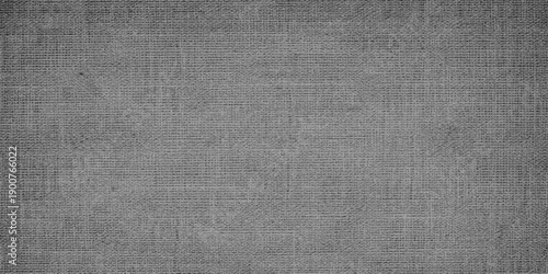 A vintage rough black and gray canvas textile material featuring a natural woven linen surface and grunge fiber pattern ideal for a blank textured cloth backdrop