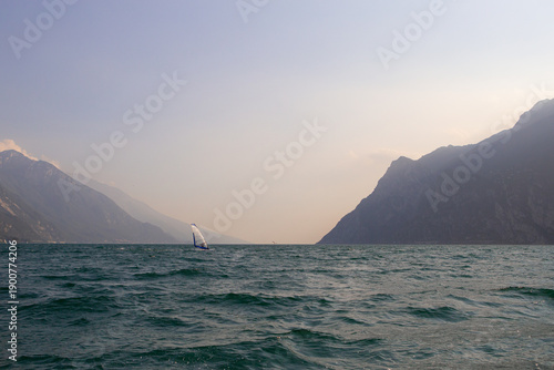Boat on Lake Garda with Windsurfer and Mountain Landscape