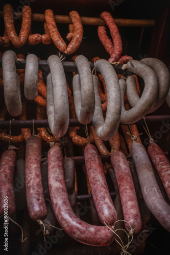 Authentic traditional meat processing with sausages and liver sausage hanging in a smokehouse.
