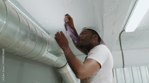 Man inspects ductwork in a building to check for airflow issues and improve HVAC system performance