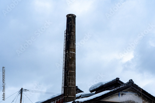 Tall Bathhouse Chimney Rising Above Snowy Japanese Neighborhood