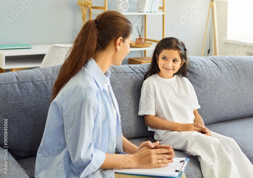 Child and counselor in therapy session dialogue. Psychologist listens, offering guidance and support in clinic with clipboard for consultation. Concept caring, mental health and psychology support.