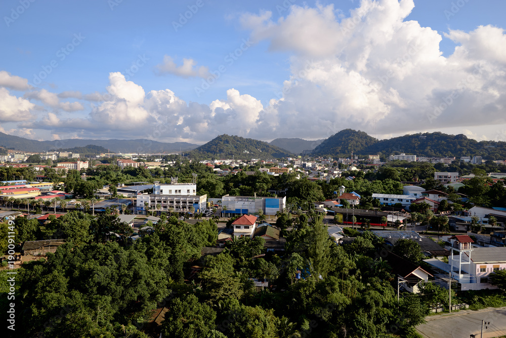 Obraz premium Scenic Cityscape With Hills and Lush Greenery Under a Blue Summer Sky