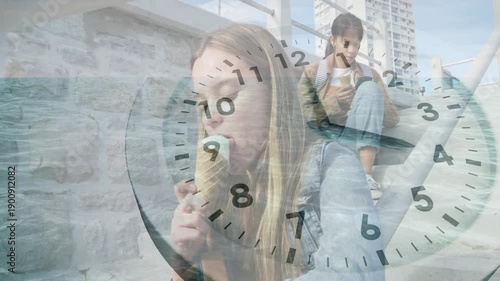 Two teen girls sitting on steps, warm sun urging girl eating cone, clock overlay advancing, leisure