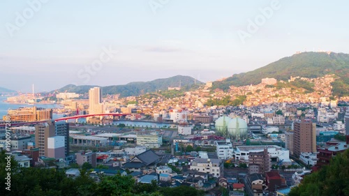 Nagasaki, Japan. Aerial timelapse made from a hill in Nagasaki, Japan, with a view over the entire center, including the bay and the hills. Cloudy and sunny day in summer, zoom in
