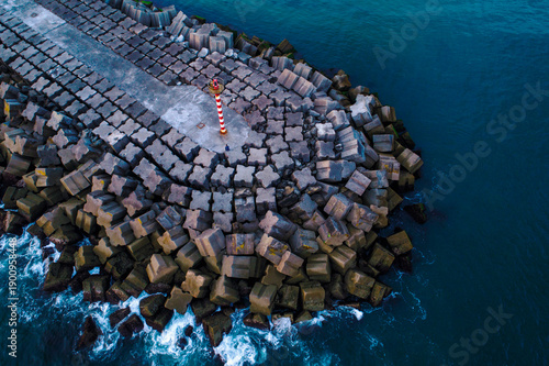 Фотография Aerial view of breakwater with red and white striped beacon The Concept of Safet
