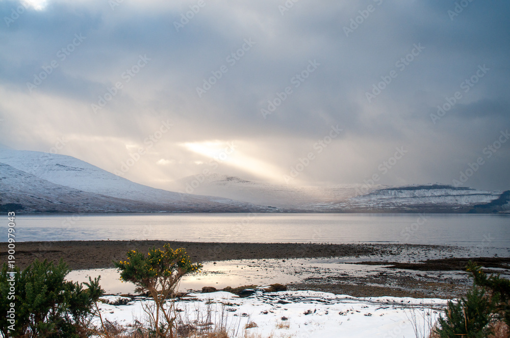 Fototapeta premium Winter Coastal Landscape with Snowy Hills and Calm Water