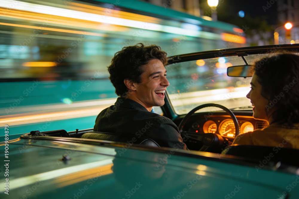 Naklejka premium Happy young man and woman driving vintage convertible car at night in the city, enjoying joyful moments and vibrant urban lights in a relaxed, carefree atmosphere.