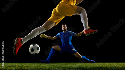 Fényképezés Soccer goalkeeper blocking shot during one on one duel on black background