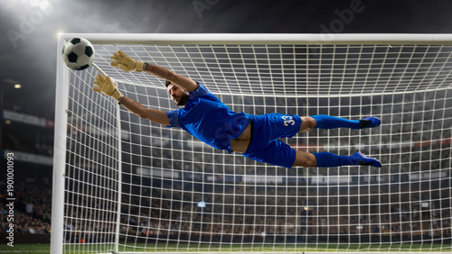 Soccer goalkeeper flying save near goal crossbar in stadium. Concept of decisive goalkeeping moment, last line defense, professional football match action, sports advertising, and editorial coverage