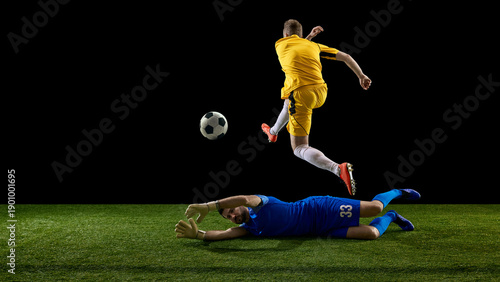 Bild auf Leinwand Soccer striker jumping over fallen goalkeeper during goal attempt