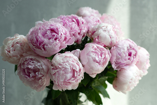 Soft pink peonies in a glass vase