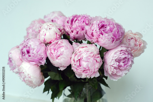 Soft pink peonies in a glass vase