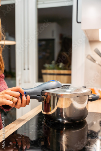 фотографія A woman is cooking in a pressure cooker