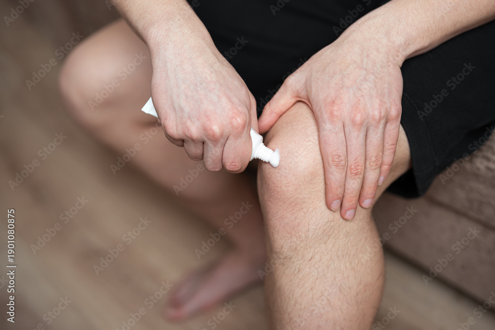 Ταπετσαρία man applying ointment cream on  his knee, knee pain