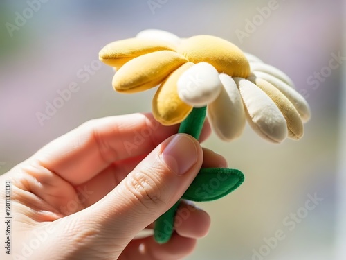 Hand holding vibrant fabric daisy showcasing artisanal craftsmanship detail