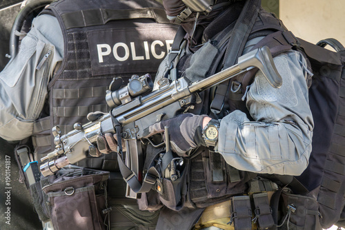 Wallpaper Mural Armed SWAT police officer in full tactical gear holding a submachine gun. Special forces soldier on a mission. Law enforcement, counter-terrorism, and security service concept. Torontodigital.ca