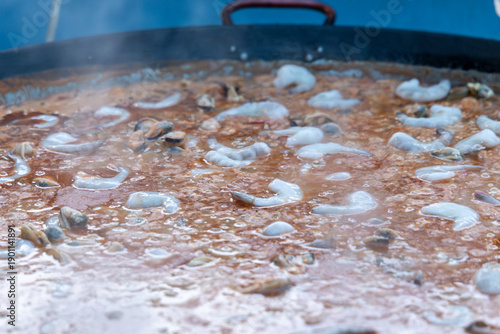 Wallpaper Mural Sizzling seafood paella with shrimp and mussels cooking in a giant traditional pan. Authentic Spanish street food steaming at an outdoor festival, a delicious culinary experience. Torontodigital.ca