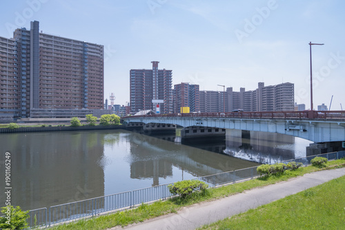 大規模な集合住宅と大きな橋がかかる河川敷の広がり