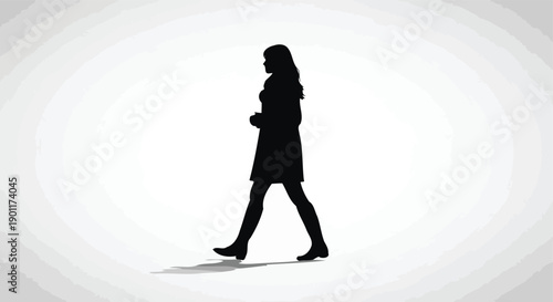 Silhouette of a woman walking confidently forward in a studio setting with soft lighting.