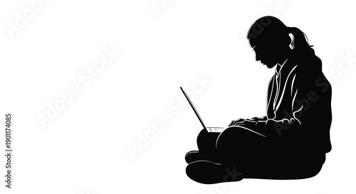 Silhouette of a young girl sitting cross-legged on the floor, intently focused on her laptop screen, with her head bowed in concentration.