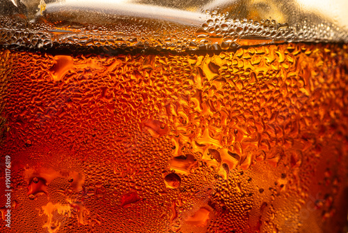 Tableau sur toile Cola drink macro: A large-scale abstract of carbonated gas bubbles in an amber liquid,A detailed macro shot featuring thousands of tiny bubbles and condensation on a glass surface, illuminated