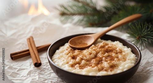 Rice pudding with cinnamon sticks and wooden spoon