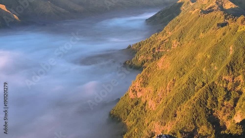 aerial view flying to mount Bromo active volcano above sea of clouds, Java, Indonesia
