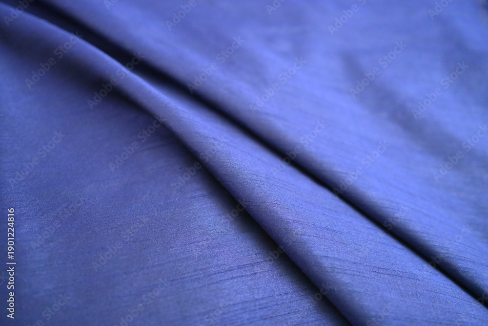 Fototapeta premium Soft folds of luxurious blue fabric texture