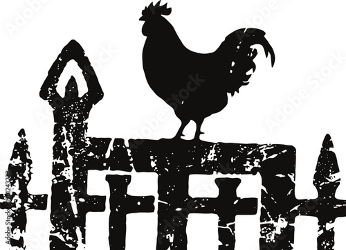 Silhouette of rooster standing on rustic weathered wooden fence with pointed stakes