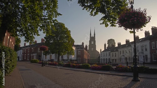 Wallpaper Mural Town Square Serenity: A picturesque view unfolds, showcasing a quaint town square adorned with classic buildings and lush greenery, embodying the charm and history of a bygone era. Torontodigital.ca