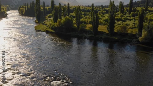 Wallpaper Mural Serene River Vista: A tranquil river meanders gracefully through a lush landscape, its waters reflecting the clear sky above and bordered by verdant trees. Torontodigital.ca
