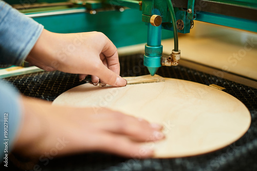 Photography Young woman skillfully works on a crafting project using a precision machine in an elegant workshop