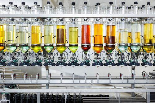 Automated fragrance filling machine in perfumery factory. Product line for perfume bottles.