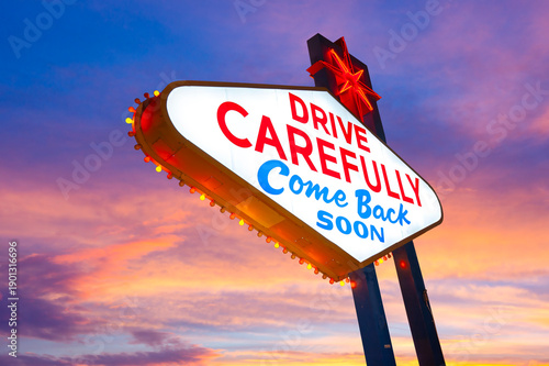 Drive Carefully Come Back Soon Sign, Welcome to Fabulous Las Vegas Sign. Logo Removed. The beautiful sunset sky in the background.