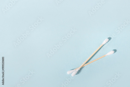 Two wooden cotton swabs for daily hygiene on blue background