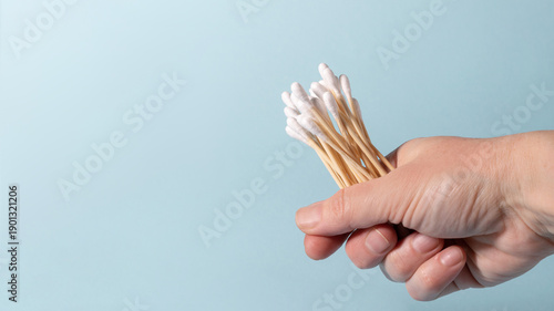Hand holding eco-friendly bamboo cotton swabs for hygiene