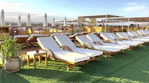 Modern rooftop resort terrace with luxury sun loungers and umbrellas in a relaxing outdoor setting. Concept of travel, leisure, vacation, hospitality and lifestyle.