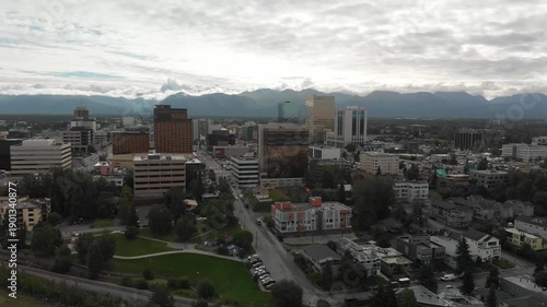 Alaska, Anchorage, Aerial view of the capital with houses and streets, mountains and clouds in the background