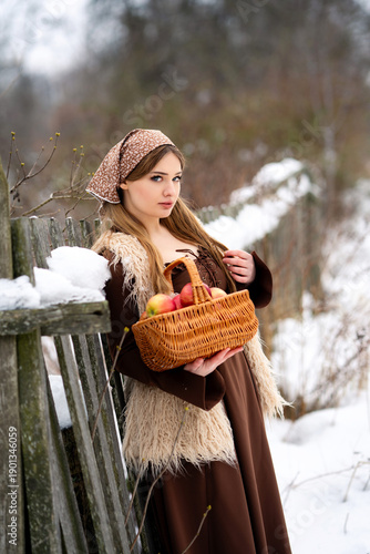 Young Woman Holding Basket of Apples in Snowy Winter Forest, Rustic Lifestyle Portrait