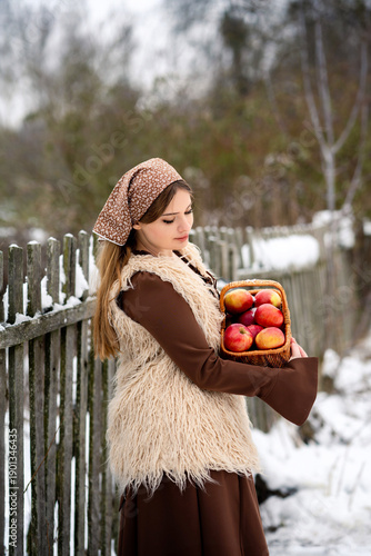 Young Woman Holding Basket of Apples in Snowy Winter Forest, Rustic Lifestyle Portrait
