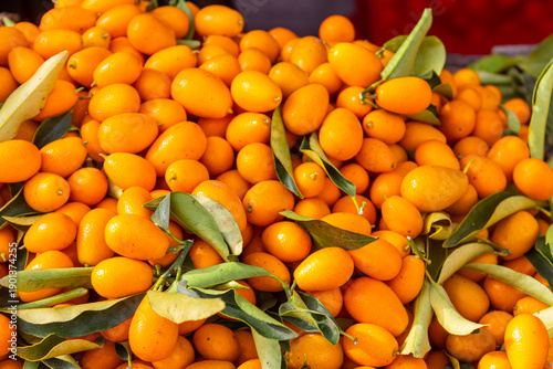 фотографія Fresh kumquat fruits for sale on a market stall