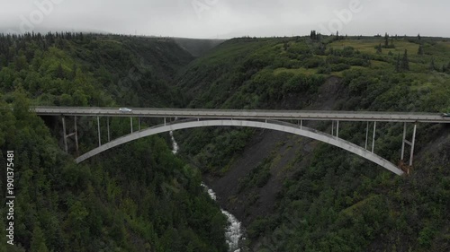 Arch Bridge,Gulch Bridge, Parks Highway Hurricane over green valley with river and trees in Alaska, aerial view