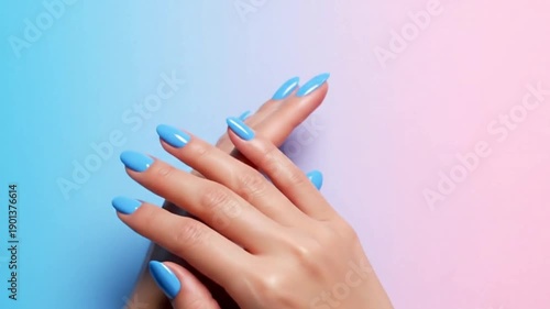 Two hands with light blue manicured nails are clasped together against a gradient backdrop