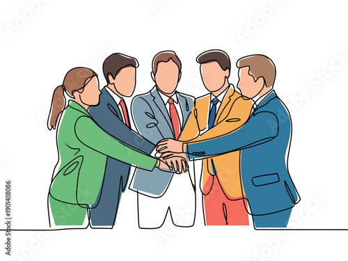 A group of business professionals stacking their hands in a symbol of teamwork and unity
