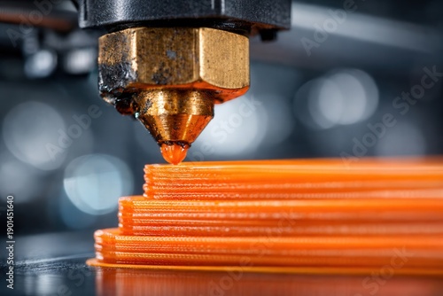 A stack of orange plastic straws is being cut by a machine with a gold-colored blade.