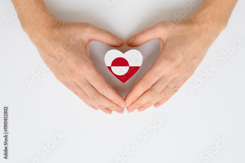 The national flag of Greenland in female hands.